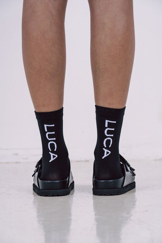 The-black-ankle-socks-with-the-LUCA-text-and-the-black-two-strap-slide-sandals-