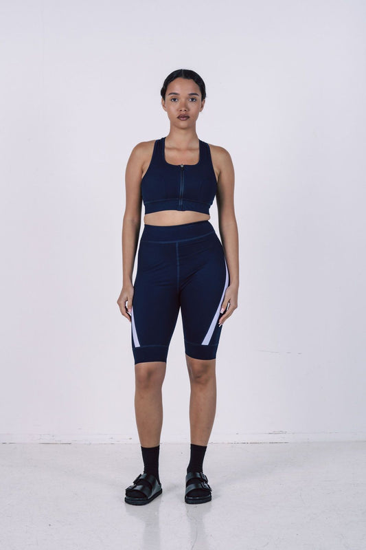 Navy-blue-seamless-cycling-set- with-white-stripes-featuring-a-zip-up-sports-bra-and-compression- cycling-shorts-for-women's-fitness