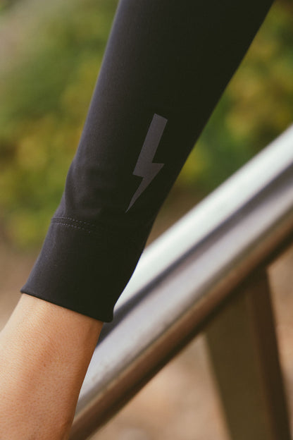 Extreme-close-up-of-the-black-long-sleeve-jersey-forearm-highlighting-the-subtle-dark-gray-lighting-bolt-sign-detail-near-the-cuff-the-seamless-finish-of-the-sleeve-hem-is-also-visible