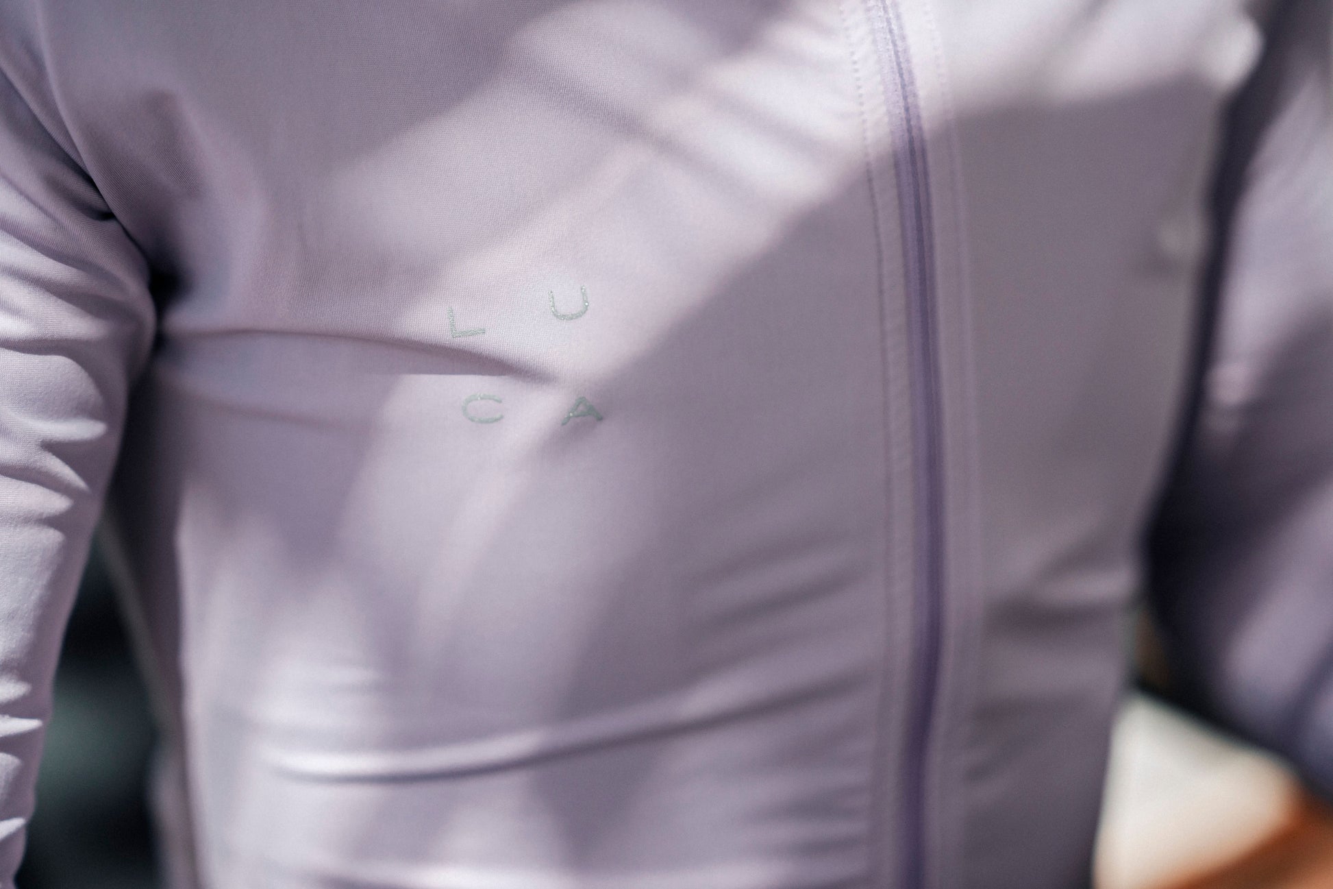 Close-up-of-a-person-wearing-the-Lilac-LUCA-Horizon-cycling-jersey-showing-the-soft-Italian-fabric-full-length-zipper-and-tailored-fit