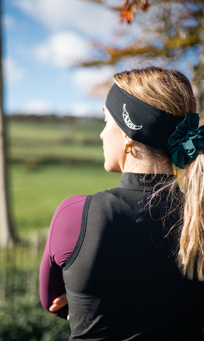 Close-up-of-a-woman-from-the- back-wearing-a-black-sports-brave- headband-with-a-logo