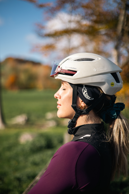 Woman-wearing-a-white-Sweet- Protection-cycling-helmet-and-black-Luca-headband-outdoors