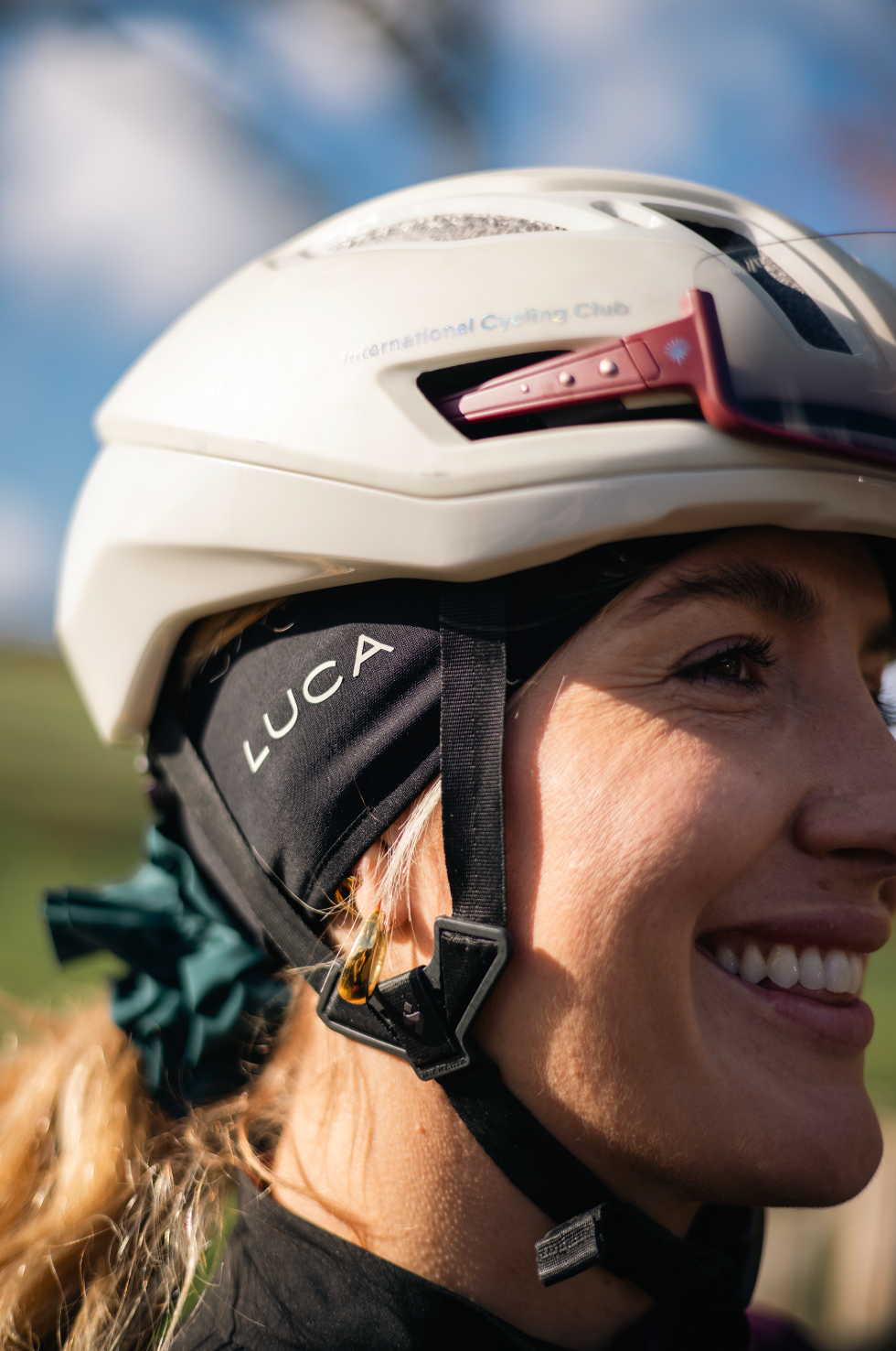 Woman-wearing-a-white-cycling- helmet-and-a-black-Luca-brand- headband-underneath